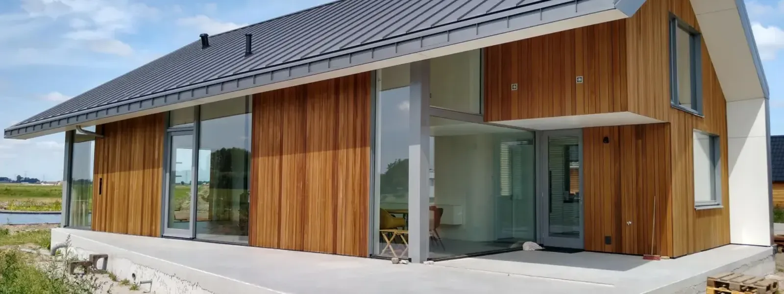 Woonhuis met een dak in zinklook, in donkere staande fels naast een houten gevel