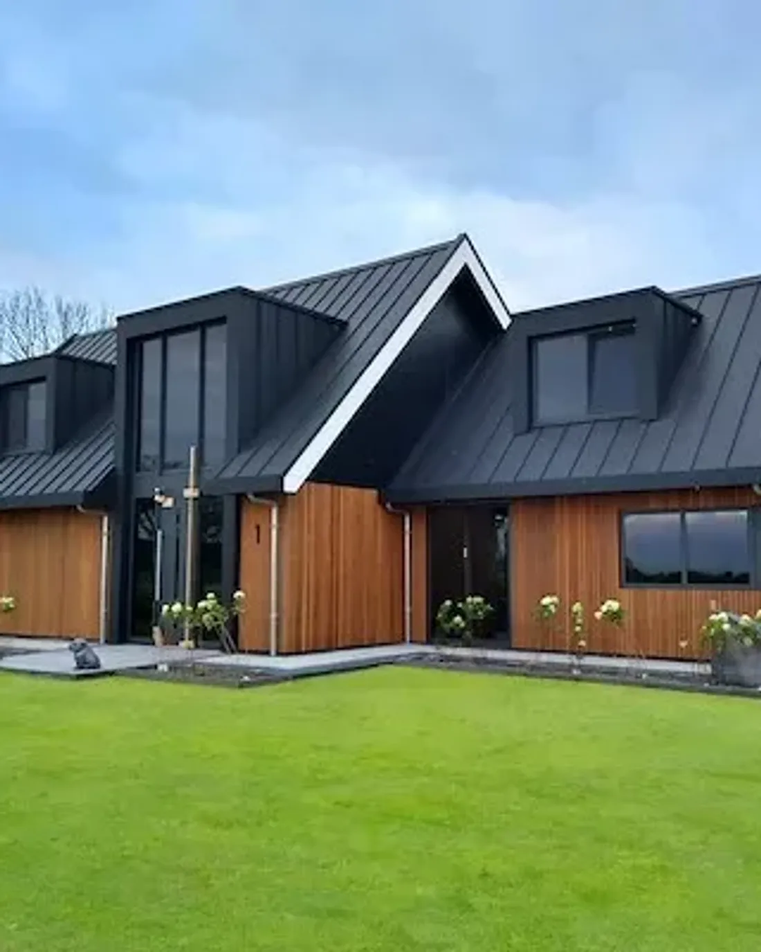 Woonhuis met een zwart zinklook-dak en twee dakkapellen