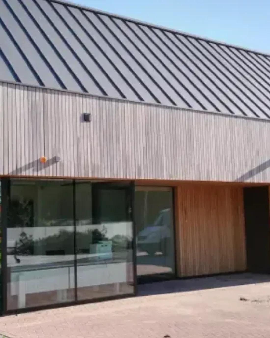 Bedrijfsgebouw met zinklook naast een lichte houten gevel