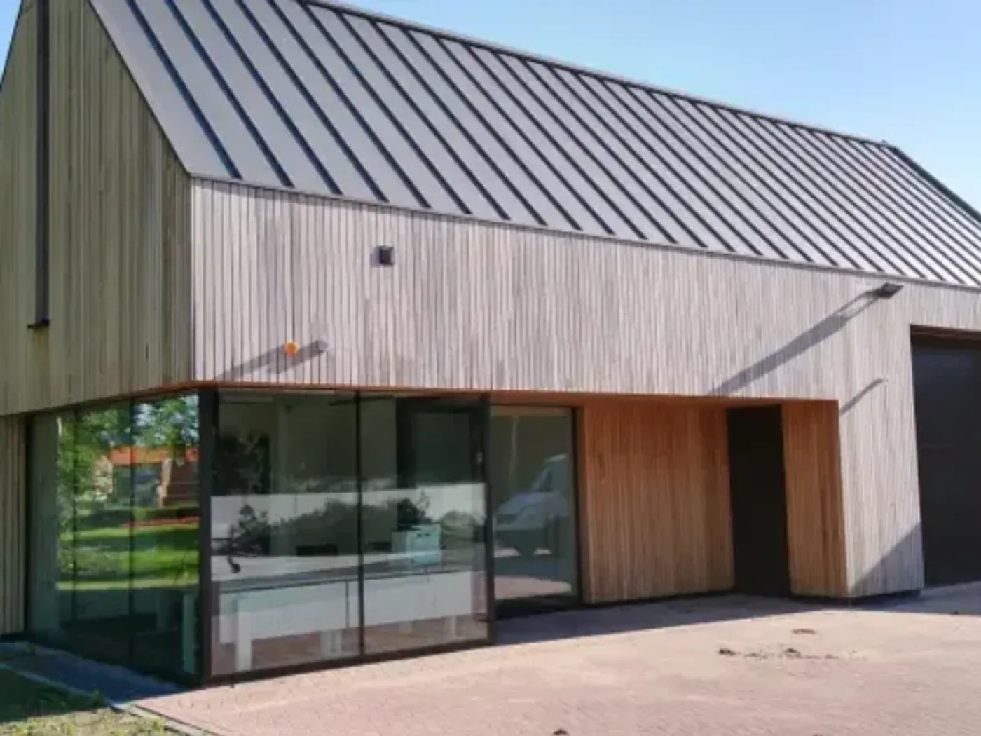 Bedrijfsgebouw met een lichte houten gevel en zinklook in staande fels